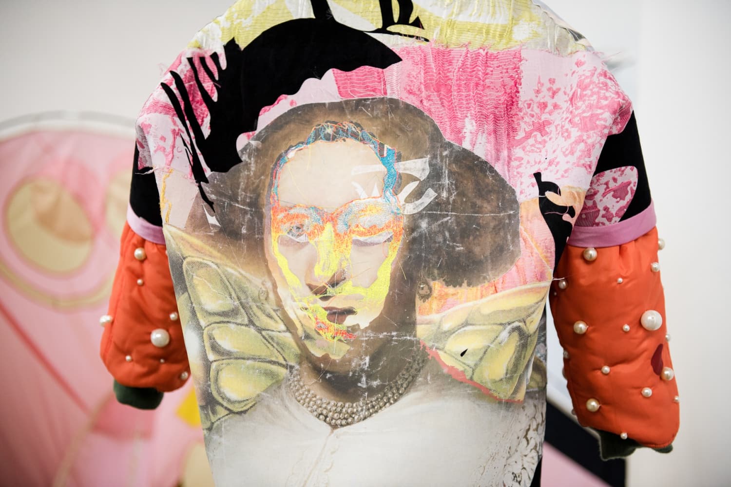 The image shows the back of a jacket WIP. Many different pieces of fabric are being stitched together.