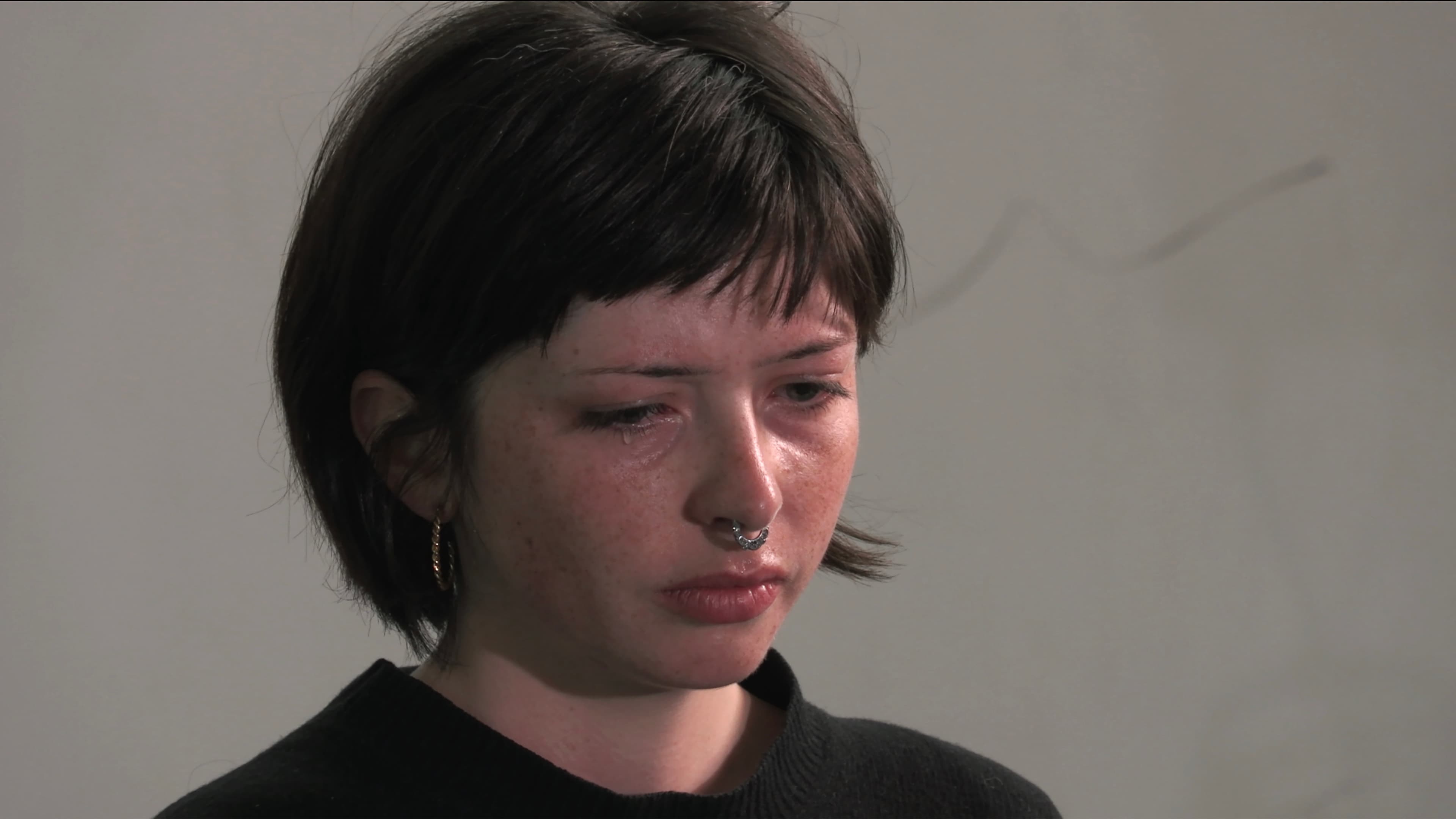 Headshot of a woman, tear falling down