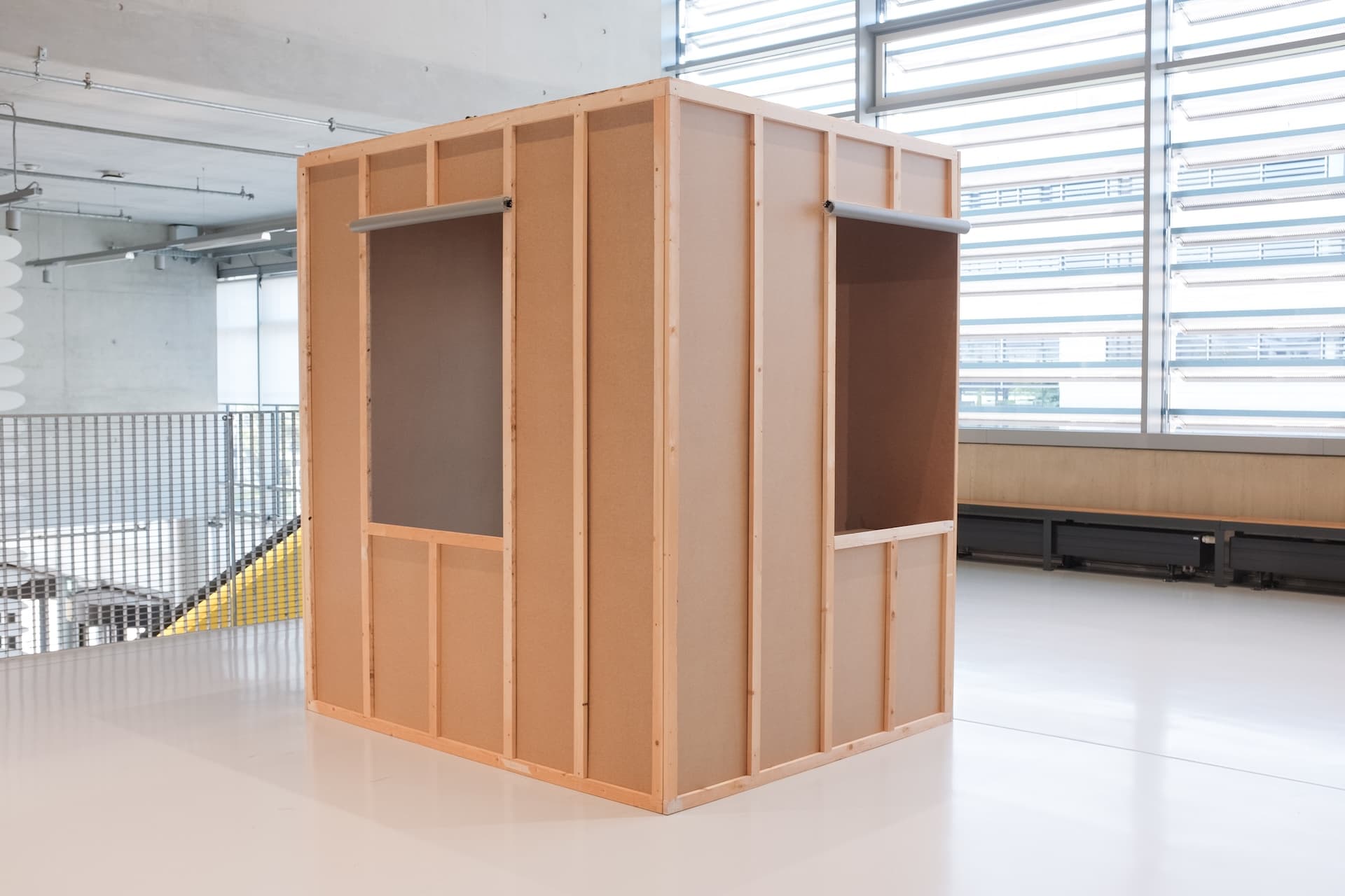 picture of a room box, 2 meters wide and 1,62 meters long in an open space in a public school. backside of the room, 2 windows visible. 