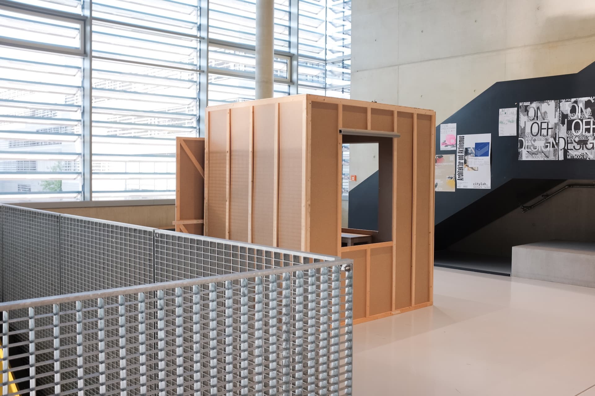 picture of a room box, 2 meters wide and 1,62 meters long in an open space in a public school. backside of the room, 2 windows visible. 