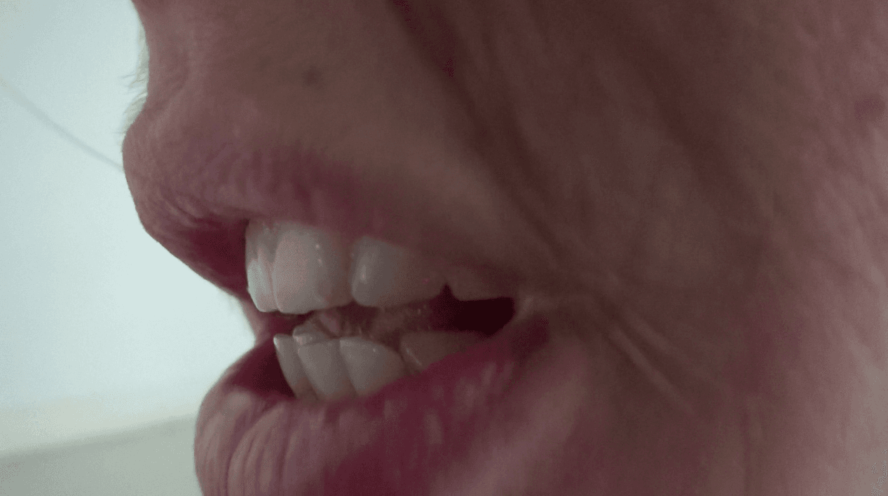 The image shows a close up shot of someone's mouth while speaking.